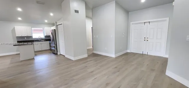 a view of a kitchen with a stove wooden cabinets and a refrigerator