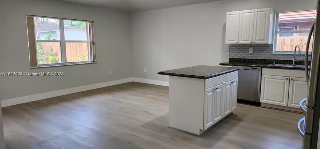 a kitchen with granite countertop a sink and a stove top oven