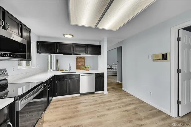 a large kitchen with stainless steel appliances granite countertop a refrigerator a sink dishwasher a stove and a microwave oven on granite countertops