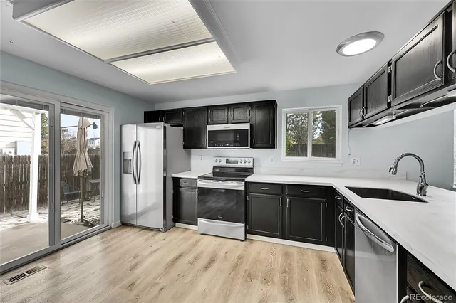 a kitchen with stainless steel appliances granite countertop a sink stove microwave refrigerator and cabinets