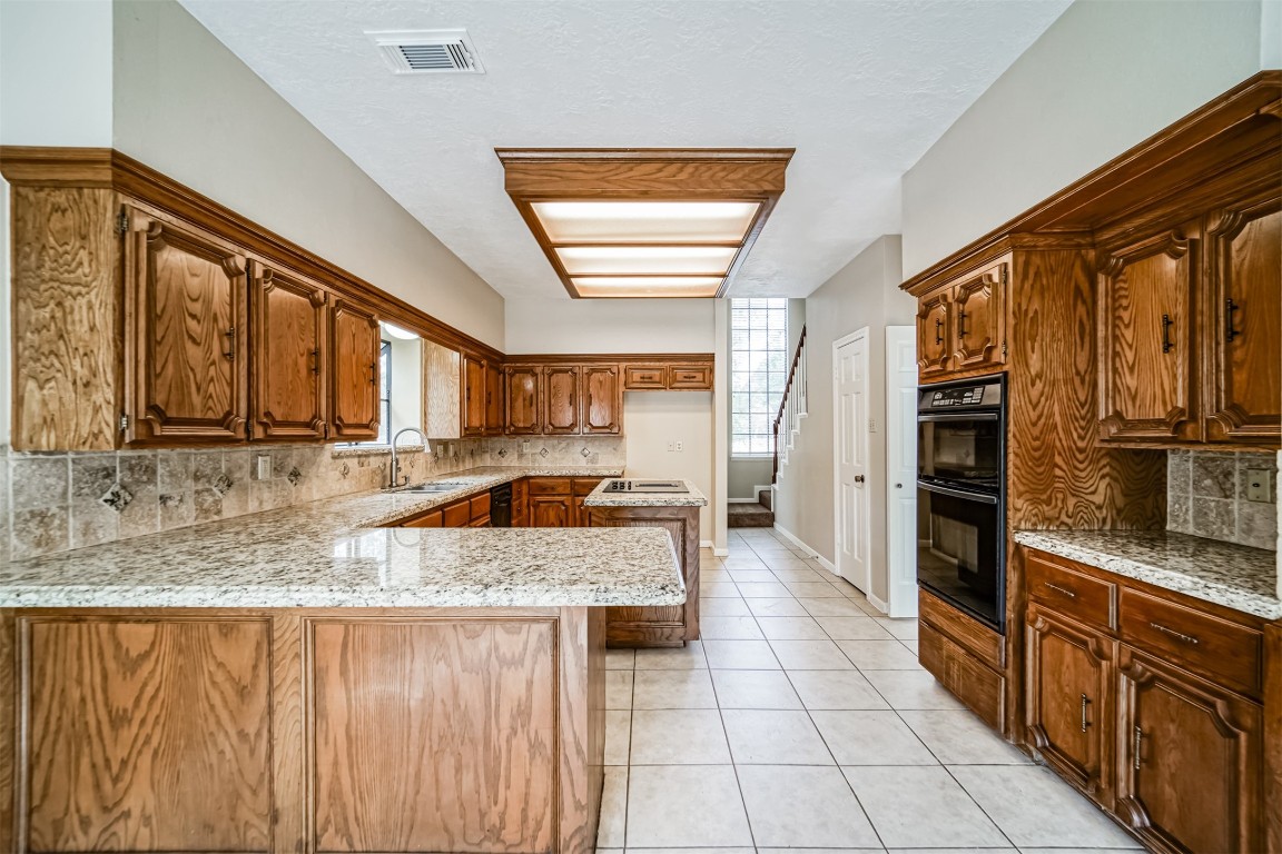 67 North Skyflower Court Spring, TX 77381 - Photo 15 of 45 a kitchen with stainless steel appliances granite countertop a stove a sink and a microwave