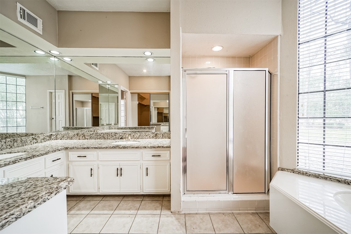 67 North Skyflower Court Spring, TX 77381 - Photo 25 of 45 a bathroom with a granite countertop sink a mirror and a bathtub