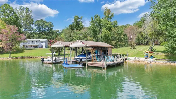 a view of a lake with lawn chairs under an umbrella