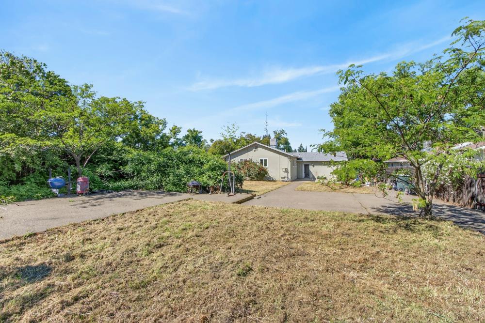 8780 Elm Avenue Orangevale, CA 95662 - Photo 21 of 23 a white house with a field covered with large trees
