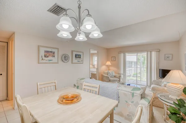 a view of a dining room with furniture a chandelier and wooden floor