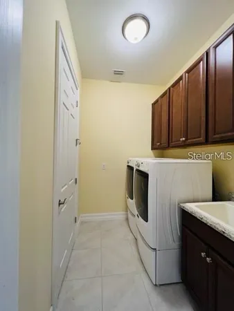 a utility room with sink dryer and washer