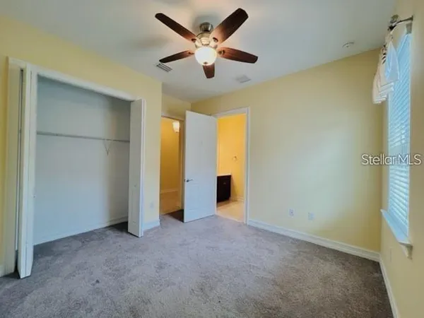 a view of an empty room with a ceiling fan