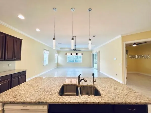 a kitchen with kitchen island granite countertop a sink a counter top and stainless steel appliances