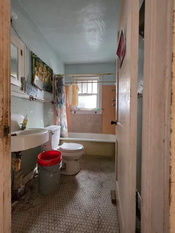 a bathroom with a sink toilet a mirror and bathtub