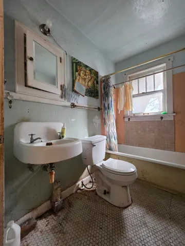 a bathroom with a toilet sink and mirror