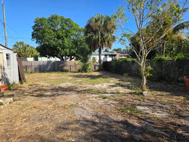 a view of backyard with cabin and potted plants