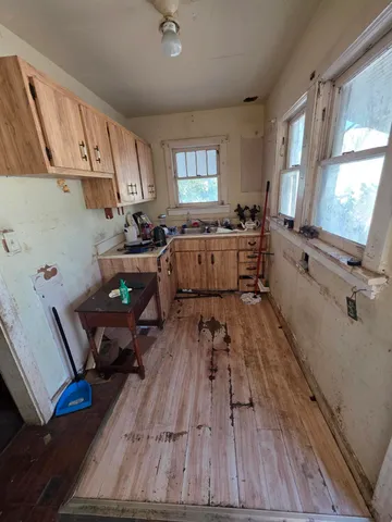 a kitchen with sink cabinets and wooden floor