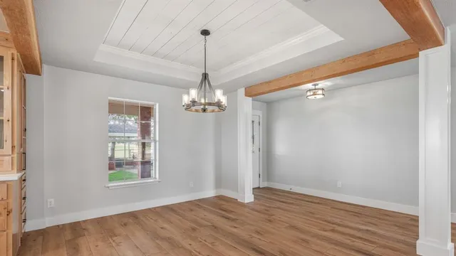 a view of empty room with wooden floor fireplace and window