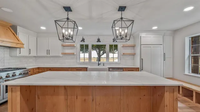 a kitchen with stainless steel appliances granite countertop a sink window and cabinets