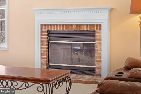 a kitchen with stainless steel appliances kitchen island granite countertop a refrigerator a stove a dining table and chairs with wooden floor