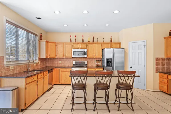 a kitchen with stainless steel appliances granite countertop a sink a stove and a refrigerator