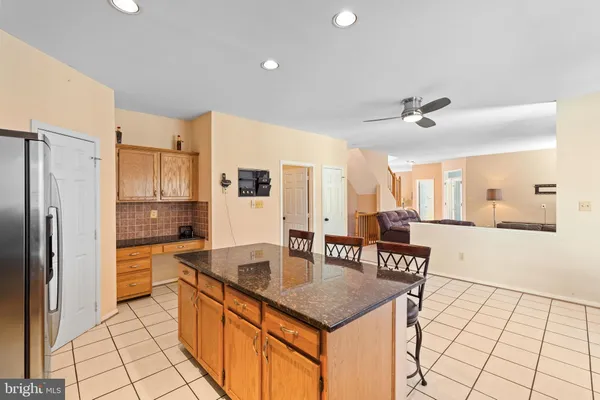 a kitchen with stainless steel appliances granite countertop a stove top oven a sink a dining table and chairs