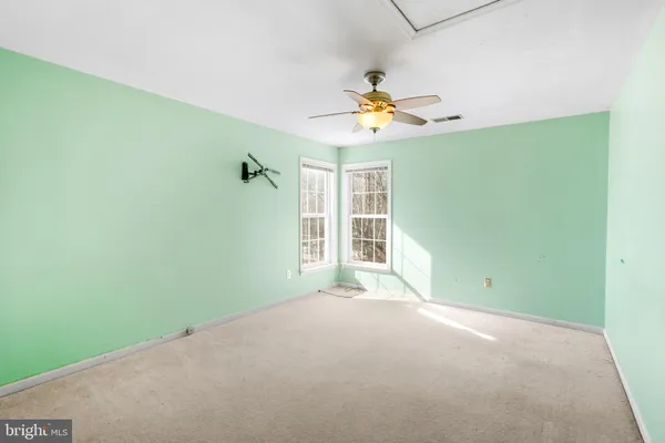 a spacious bathroom with a granite countertop sink a toilet a mirror and shower
