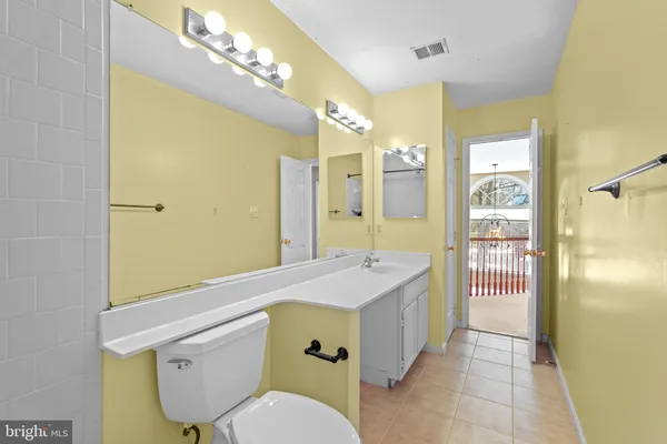 a view of a livingroom with a chandelier fan and windows