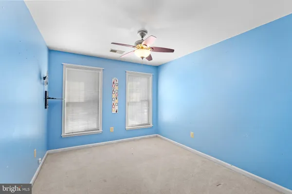 a view of empty room with a ceiling fan and a window