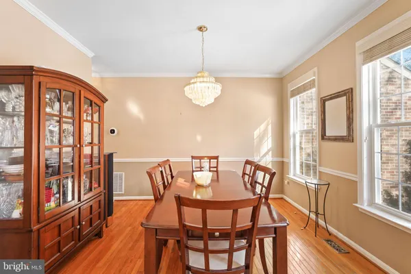 a dining room with furniture a chandelier and wooden floor
