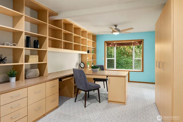 a view of a workspace with furniture and a window