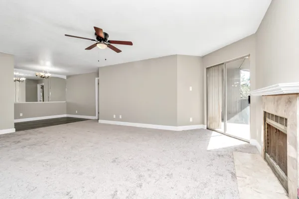 an empty room with windows and fireplace