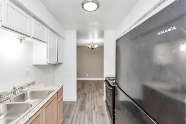 a view of a kitchen with a sink and dishwasher with wooden floor