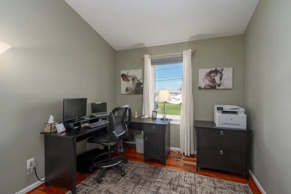 a view of a workspace with furniture and a window
