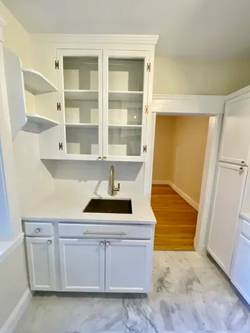a kitchen with white cabinets and sink