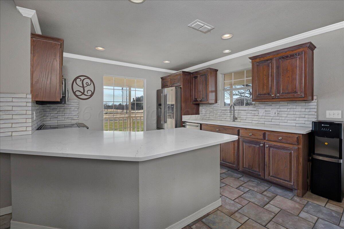 8910 Dove Road Canyon, TX 79015 - Photo 15 of 47 a kitchen with a sink a stove cabinets and wooden floor