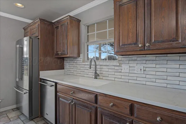 a kitchen with stainless steel appliances granite countertop a refrigerator and a sink