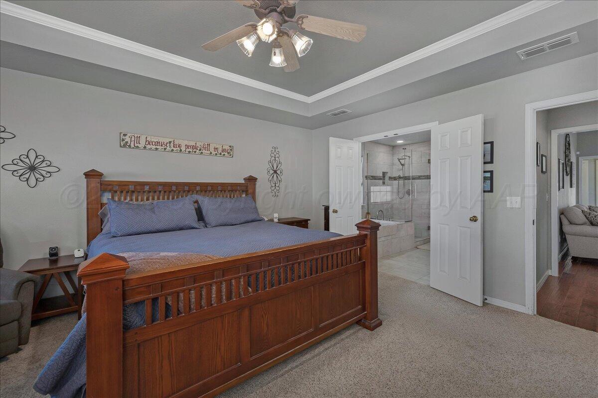 8910 Dove Road Canyon, TX 79015 - Photo 22 of 47 a bedroom with a bed and a chandelier