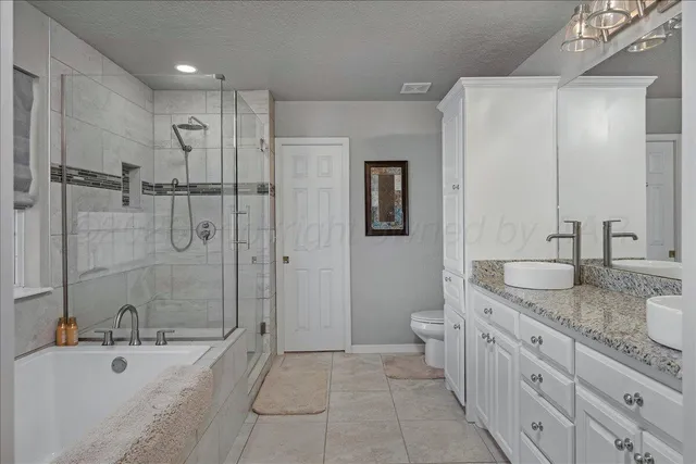 a spacious bathroom with a granite countertop sink a toilet and shower