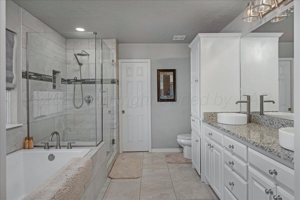 8910 Dove Road Canyon, TX 79015 - Photo 23 of 47 a spacious bathroom with a granite countertop sink a toilet and shower