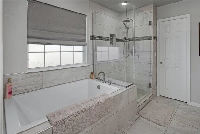 a spacious bathroom with a bathtub and a shower
