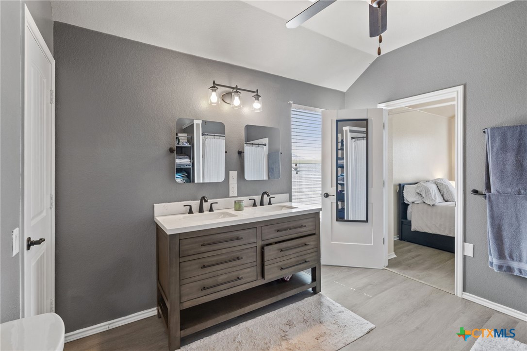 10113 Copper Ridge Cove Austin, TX 78747 - Photo 18 of 32 a en suite bathroom with a double vanity sink a mirror and a shower