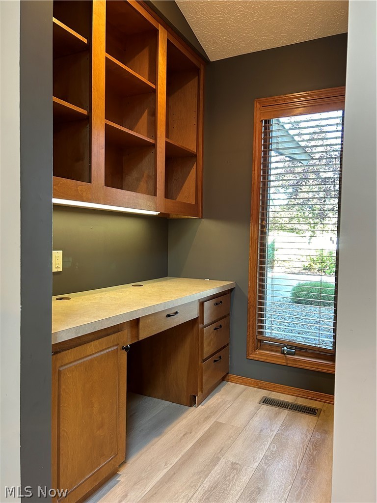 8763 Timber Edge Drive North Ridgeville, OH 44039 - Photo 12 of 40 Unfurnished office featuring built in desk, a textured ceiling, vaulted ceiling, and light hardwood / wood-style flooring