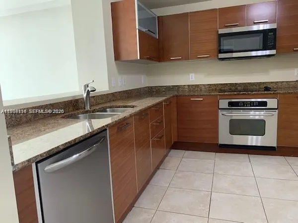 a kitchen with a stove a microwave and cabinets
