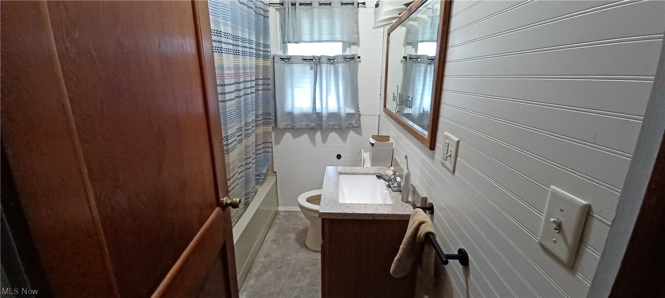 1441 State Road Northwest Warren, OH 44481 - Photo 7 of 19 Full bathroom with light tile floors, oversized vanity, mirror, and shower / bath combination with curtain
