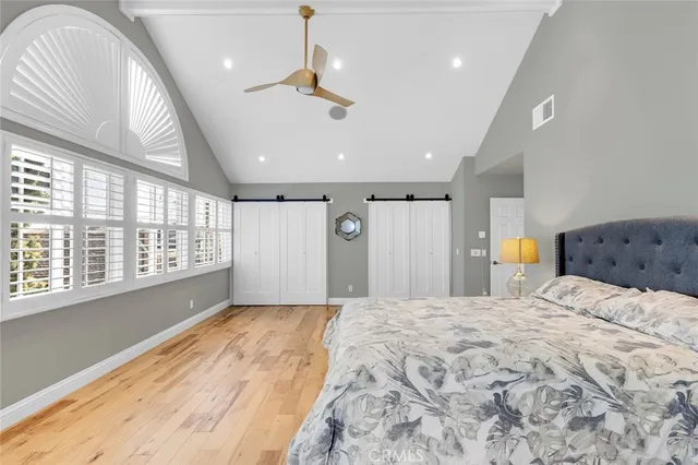 a spacious bedroom with a large bed and a large window