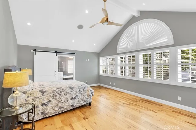 a spacious bedroom with a large bed and a chandelier