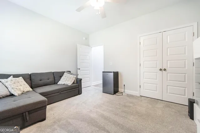 a living room with furniture a ceiling fan and a rug
