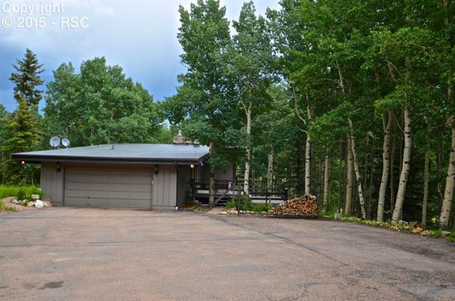 218 Worley Road Divide, CO 80814 - Photo 13 of 15 Summer view, attached garage, deck, and large south facing paved drive.
