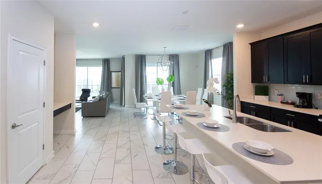 a dining room with furniture a livingroom and chandelier wooden floor