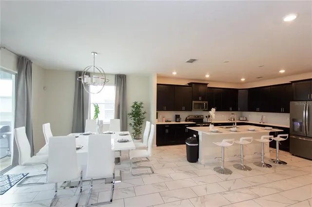 a kitchen with stainless steel appliances a sink a stove a refrigerator and cabinets