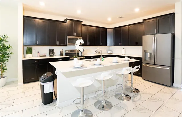 a kitchen with a sink a stove a refrigerator and cabinets