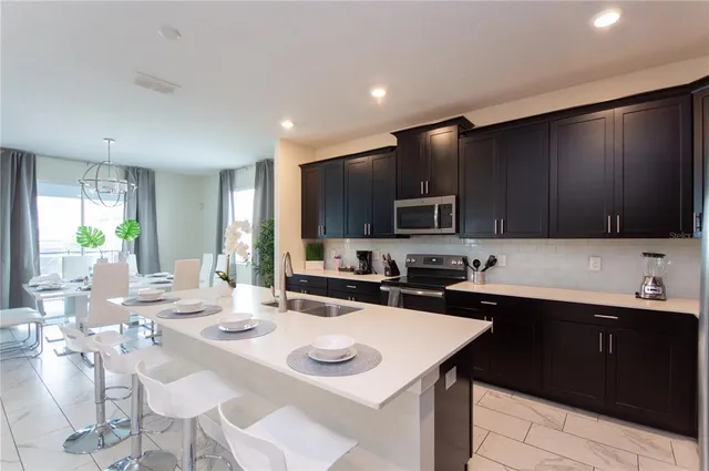 a dining room with furniture a potted plant and a chandelier