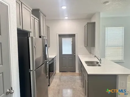 a kitchen with stainless steel appliances a refrigerator and a sink