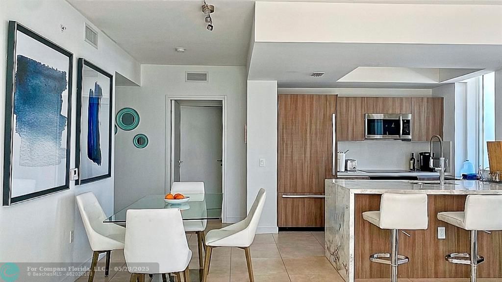 401 North Birch Road, Unit 415 Fort Lauderdale, FL 33304 - Photo 11 of 33 a kitchen with stainless steel appliances granite countertop a sink and a refrigerator